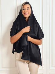 Smiling woman wearing a black 100% Mulberry silk long scarf/shawl, draped over her head and shoulders.