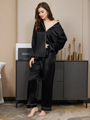 Women's black mulberry silk long sleeve button-up pajama set with white piping.