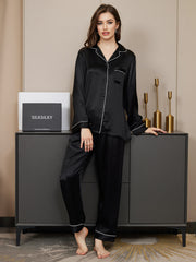 Women's black 100% mulberry silk long sleeve button-up pajamas set with white piping detail.