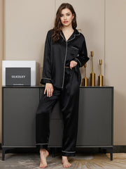 Black mulberry silk long sleeve button-up women's pajamas set with white piping, shown on a model.