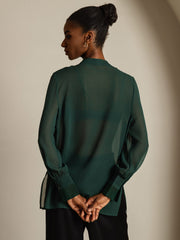 Women's sheer mulberry silk long-sleeve blouse in dark green, styled with split sides.