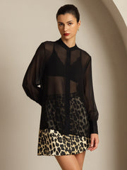 Black sheer mulberry silk long sleeve blouse over a leopard print skirt.
