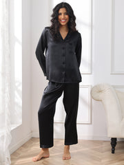 Smiling woman in black 100% mulberry silk long sleeve women's pajamas set.