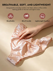 Blush pink 100% Mulberry silk low-rise panty with ruffle trim, held by a hand.