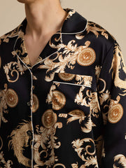 Men's black mulberry silk pajamas with gold dragon and baroque print, white piping, notch collar, and chest pocket.