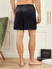 Men's black mulberry silk lounge shorts, sleep bottoms with elastic waist, shown from behind.