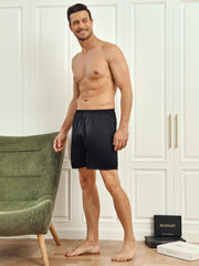 Smiling man wearing black 100% mulberry silk men's lounge shorts.