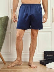 Men's navy blue mulberry silk lounge shorts with elastic waist, shown on a person.