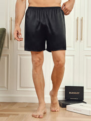 Men's black mulberry silk lounge shorts with elastic waist, shown on a model.