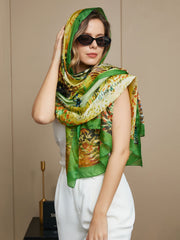 Women's mulberry silk scarf with vibrant oil painting design, worn as a headwrap and shawl.