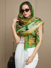 Woman wearing a green mulberry silk scarf with an oil painting design, styled as a head covering and shawl.