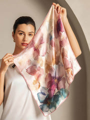 Mulberry silk square scarf with a vibrant watercolor floral pattern in pink, purple, and blue tones.