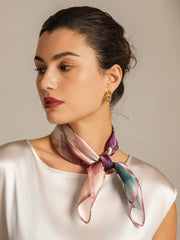 Mulberry silk square scarf with abstract pattern in pink, purple, and teal, tied around a woman's neck.