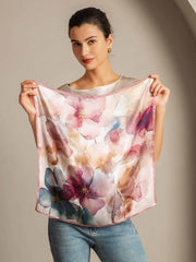 Woman holding a 53x53cm mulberry silk square scarf with a pink floral watercolor pattern.