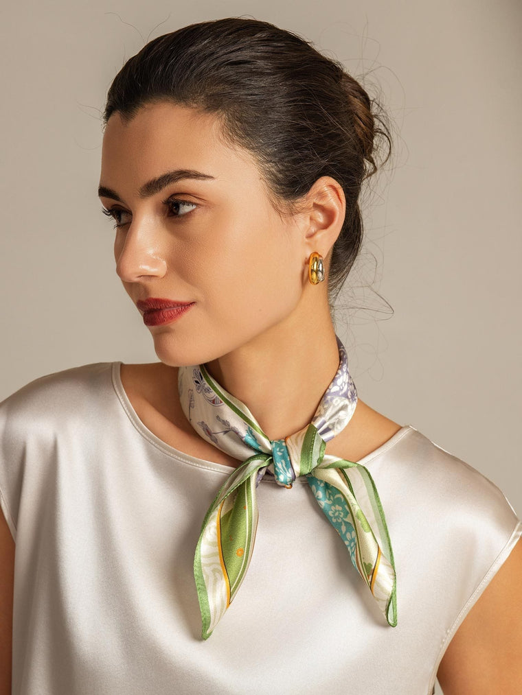 Woman wearing a 100% mulberry silk pattern stitching square scarf with green and blue accents.