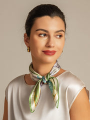 Woman wearing a 100% mulberry silk square scarf with a colorful pattern, tied around her neck.