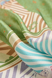 Mulberry silk square scarf with green, blue, and brown geometric pattern stitching.