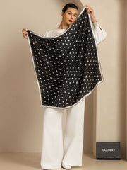 Black 100% Mulberry silk scarf with white paw print pattern, held by a woman.