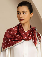 Mulberry silk scarf, red with white paw print and floral pattern, tied around a woman's neck.