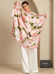 Woman holding a pink floral print mulberry silk scarf (90x90cm) with a pink border.