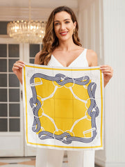 Woman holding a yellow and white mulberry silk square scarf with a navy equestrian bit and stripe print.