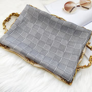 Mulberry silk long rectangle shawl scarf with black and white plaid print on a gold tray.