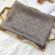 Mulberry silk printed long rectangle shawl scarf with a brown and black plaid pattern on a gold tray.