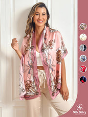Woman wearing a pink mulberry silk shawl scarf with an ornate chain and buckle print.