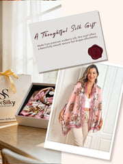 Woman wearing a pink mulberry silk printed rectangular long shawl scarf with chain and medallion pattern.