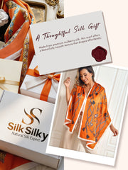 Orange mulberry silk rectangular long shawl scarf with chain print, worn by a woman.