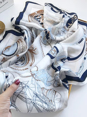 White 100% Mulberry silk square shawl scarf with blue and brown nautical print, held by a hand.