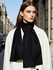 Woman wearing a black 100% mulberry silk rectangle long scarf/shawl with a white coat.