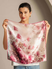 Mulberry silk scarf with a vibrant pink rose pattern, held by a woman.