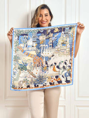 Mulberry silk scarf with a vibrant scenery pattern, held by a woman.