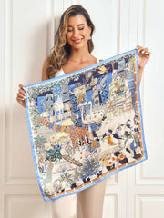 Woman holding a 68x68cm mulberry silk scarf with a vibrant blue scenery pattern.