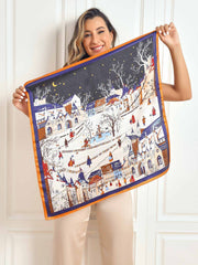 Mulberry silk scarf with a vibrant winter village scenery pattern and orange border.