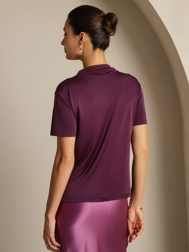 Women's mulberry silk short sleeve mock t-shirt in deep plum, paired with a pink silk skirt.