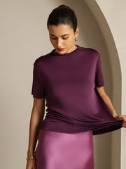 Women's mulberry silk short sleeve mock neck t-shirt in deep purple, shown with a pink silk skirt.