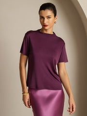 Women's mulberry silk short sleeve mock neck t-shirt in deep plum, paired with a satin skirt.