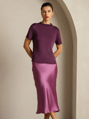 Women's mulberry silk short sleeve mock neck t-shirt in deep purple, paired with a satin midi skirt.