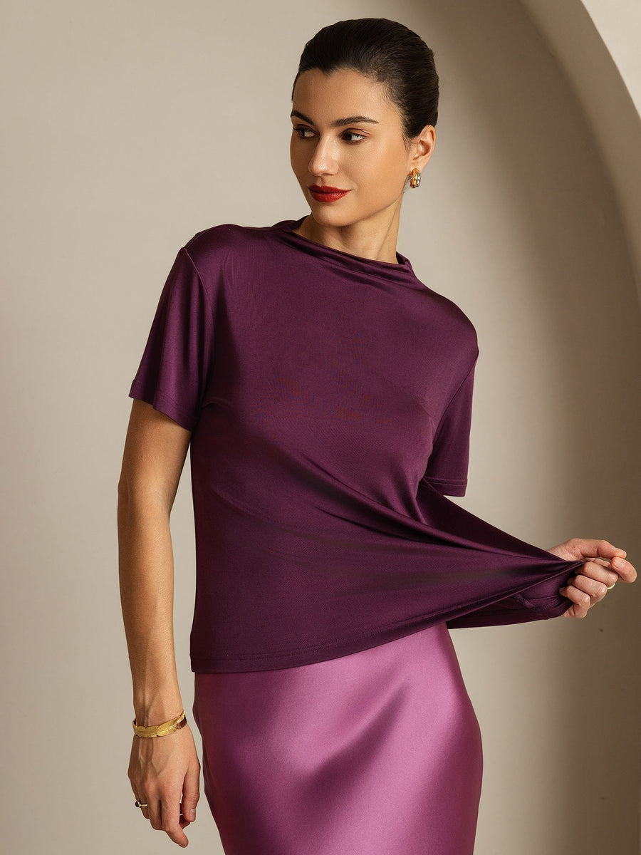 Women's mulberry silk short sleeve mock neck t-shirt in deep plum, paired with a satin skirt.