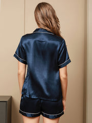 Women's navy blue mulberry silk short sleeve pajama set with white piping.