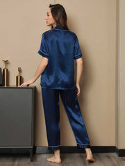 Women's navy blue mulberry silk short sleeve pajamas set with white piping, seen from behind.