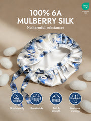 White mulberry silk sleep bonnet with blue floral pattern and tie ribbons.