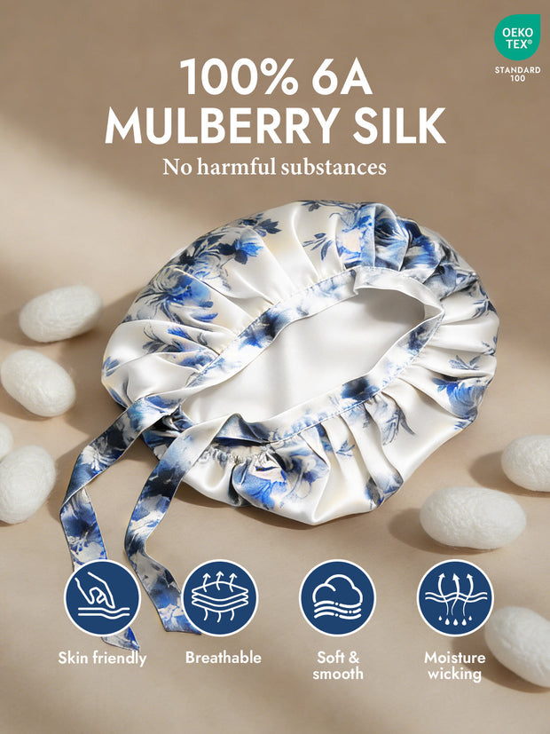 White mulberry silk sleep bonnet with blue floral pattern and tie ribbons.