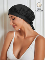 Black 100% mulberry silk sleep bonnet with ribbons, worn by a woman in a white top.