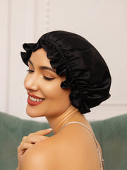 Black mulberry silk sleep cap with ruffled trim on a woman.