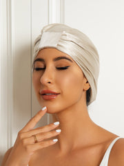 Woman wearing a champagne double-layer mulberry silk sleep cap or night turban bonnet.