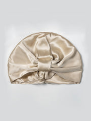Champagne mulberry silk sleep cap with a double-layer turban bonnet style and front knot detail.