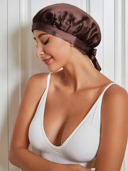 Brown mulberry silk sleep cap with tie closure on a woman.
